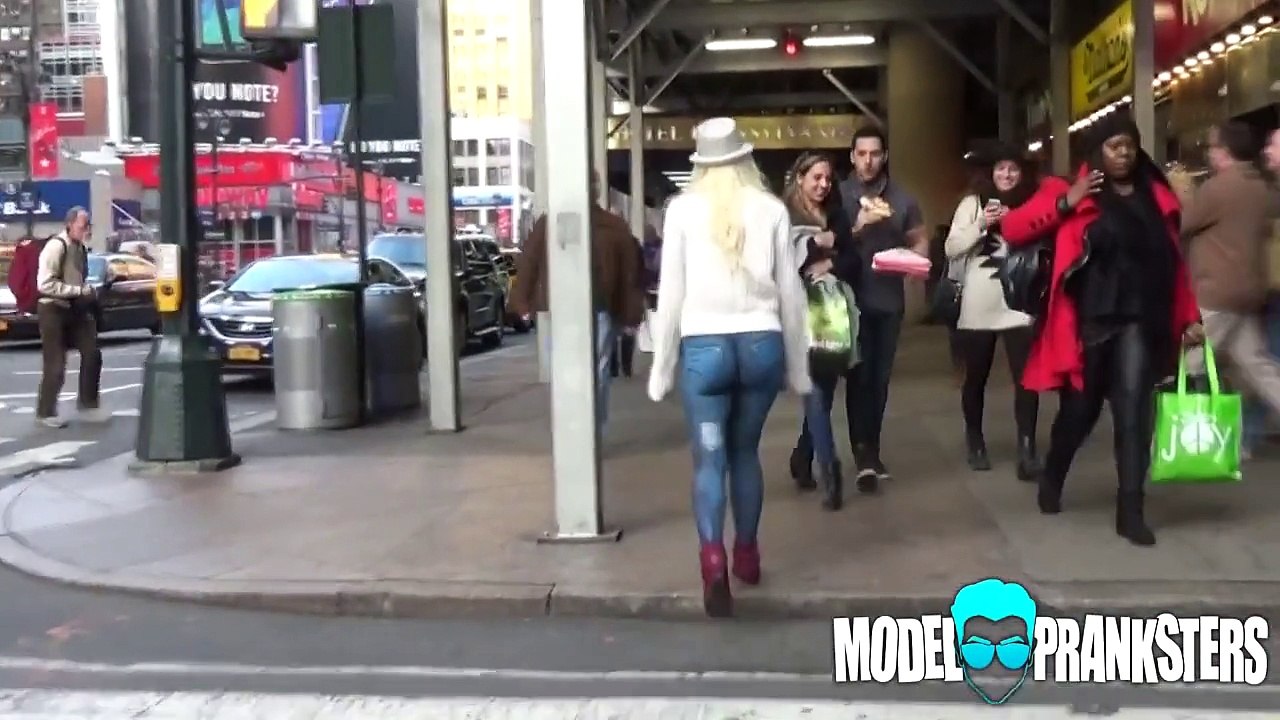 Une femme marche nue avec un pantalon peint dans New York