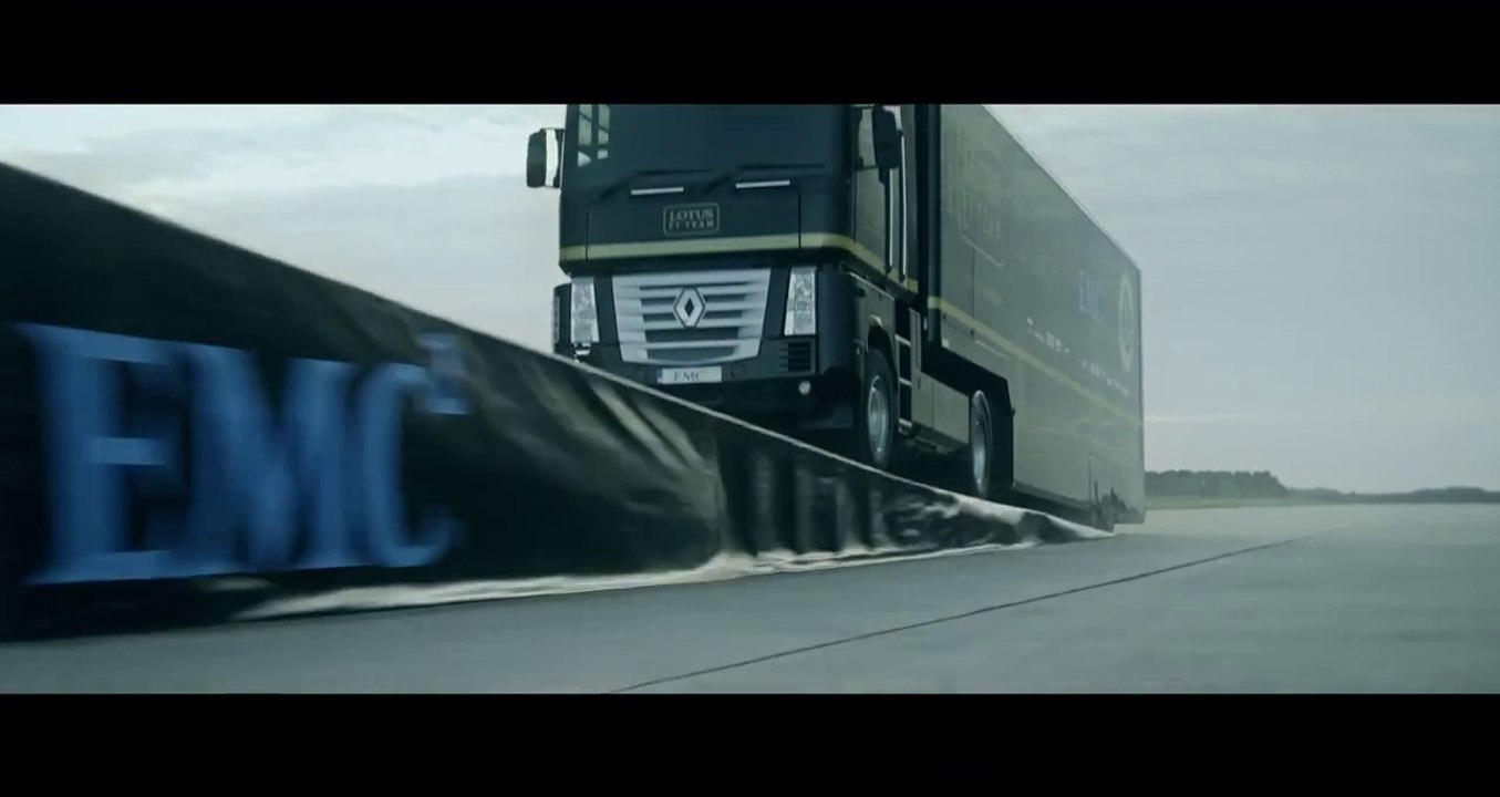 Un camion poids lourd saute au dessus d'une formule 1 pour une pub Lotus F1 Team et EMC