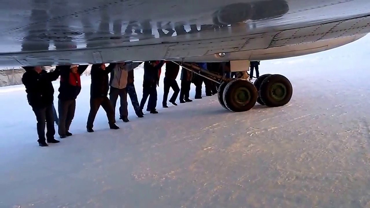 Plane passengers come together to push an aircraft frozen to the ground