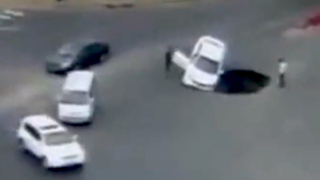 Motorist drives Car into large sinkhole