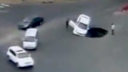 Motorist drives Car into large sinkhole