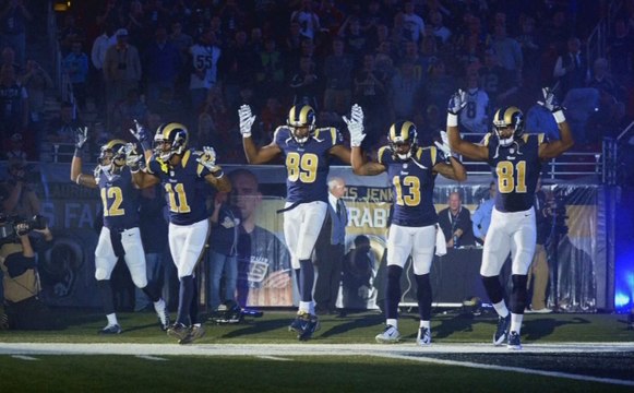 Des joueurs de football les mains en l'air en référence à Michael Brown