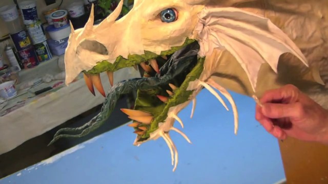 Il fabrique des têtes de dragons en papier mâché