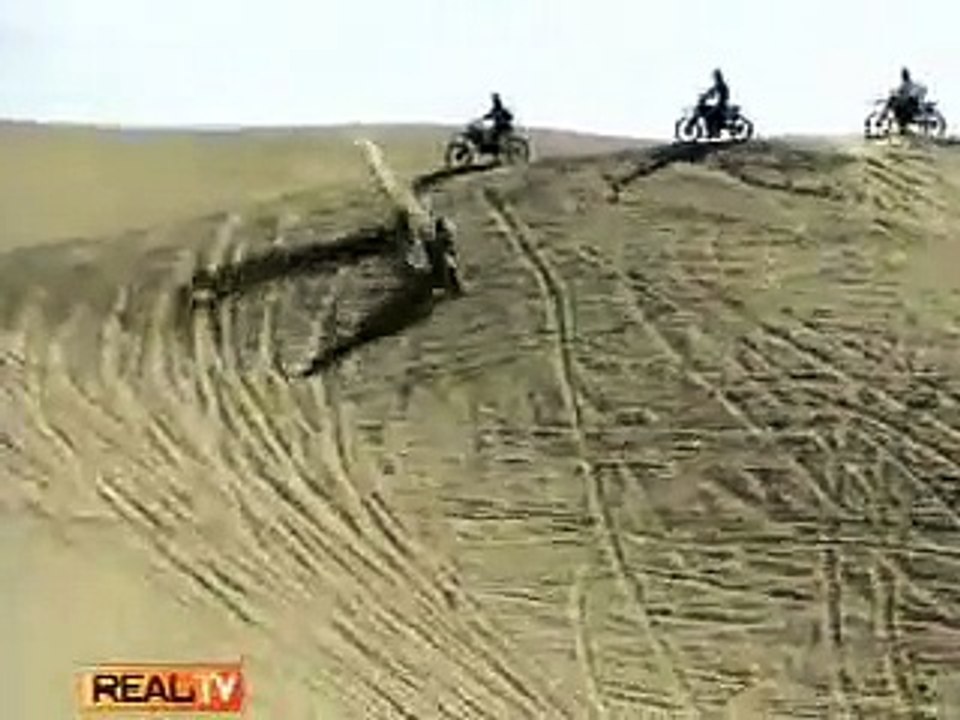 Une moto saute d'une dune