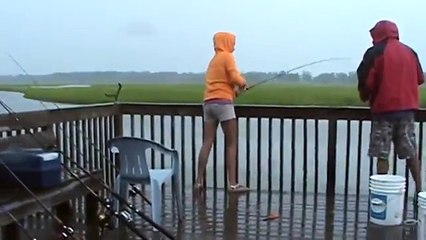 A shark jumps out of water to steal fish from a girl fishing