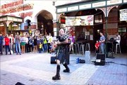 Street musician playing AC / DC with burning Scottish bagpipe