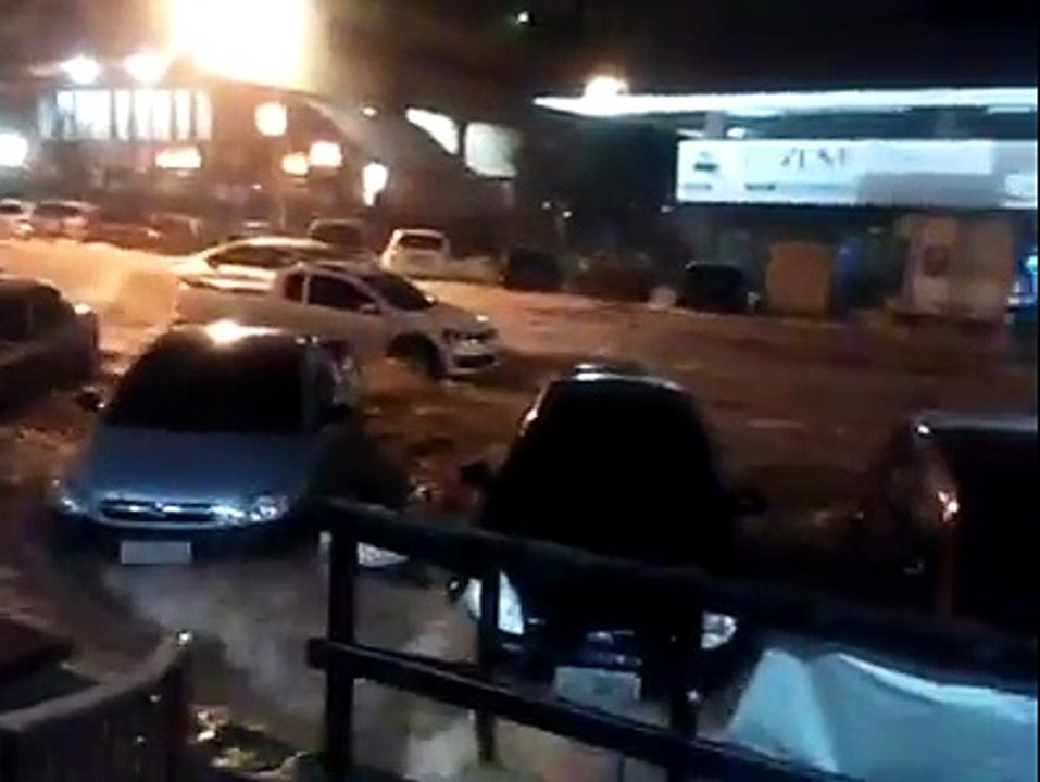 Homem é derrubado e arrastado por correnteza em rua alagada de Brasília