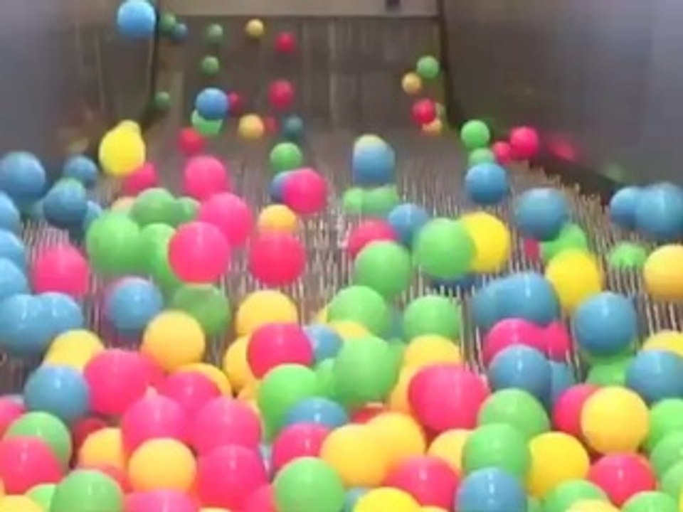 Des balles multicolores dans un escalator !