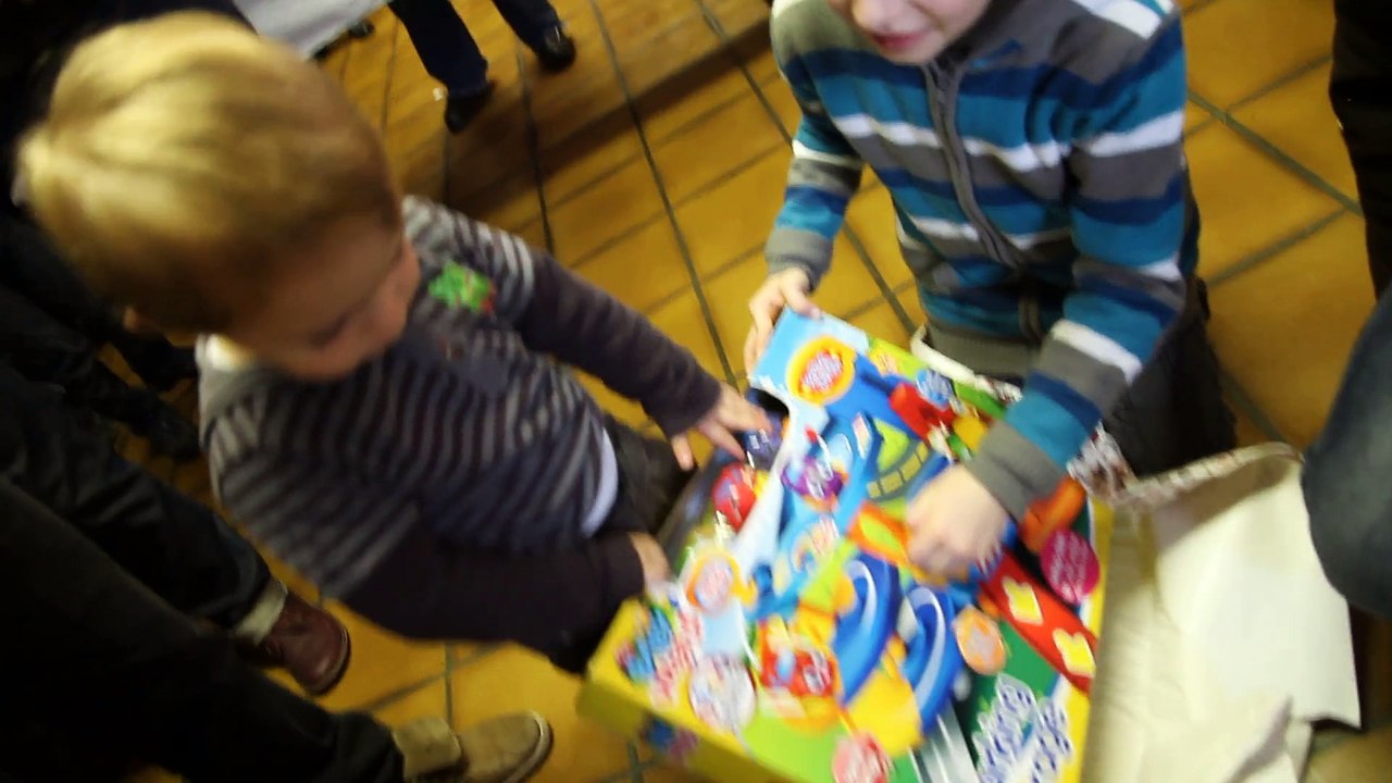Ilan qui ouvre son cadeau  à la fête d'école à Enzo