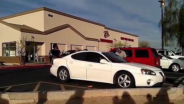 Un jeune homme accroché à l'arrière d'une voiture