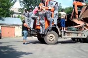 20 gars font contre-poids sur un camion pour l'aider à soulever son chargement