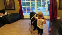 Une fillette apprend à son chien à faire du Hula Hoop!