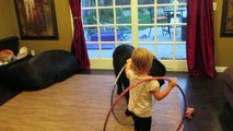 Une petite fille joue au Hula Hoop avec son chien