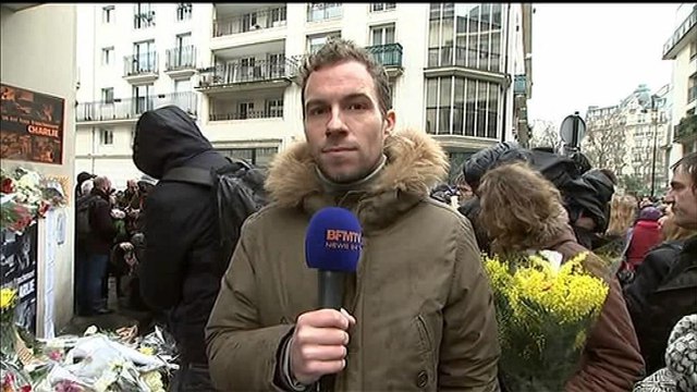 Des fleurs et des bougies déposées devant Charlie Hebdo