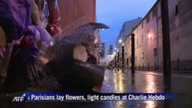 Parisians lay flowers, light candles at Charlie Hebdo