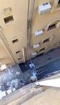 Un ouvrier répare une ventilation au sommet d'une échelle de 20 mètres