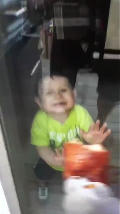 Kid Tries To Eat Food Through The Glass Door