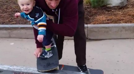 Un père qui fait découvrir le skateboard à son bébé