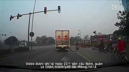 Xe máy liều chết phóng giữa xe tải và container