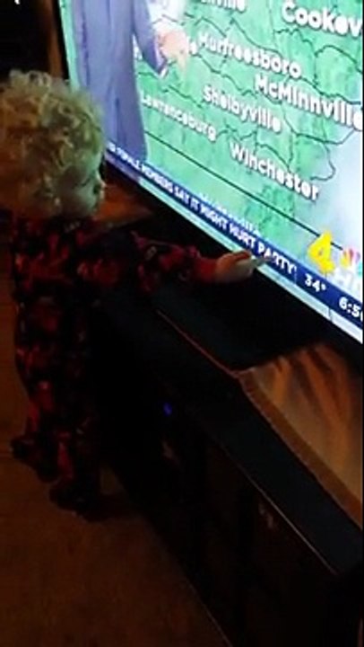 Cet enfant ne comprend pas comment le texte défile sur la télé !