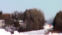 Un train fait voler de la neige sur son passage