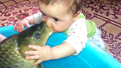 Sazan balığı ile oynayan bebek