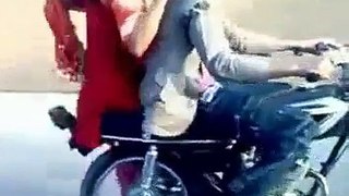 Pakistani Boy Performing One Wheeling with A Girl Sitting on Bike