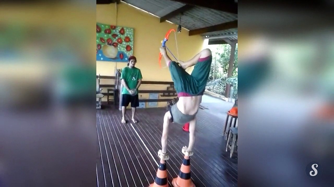 Une femme en équilibre tire à larc avec ses pieds