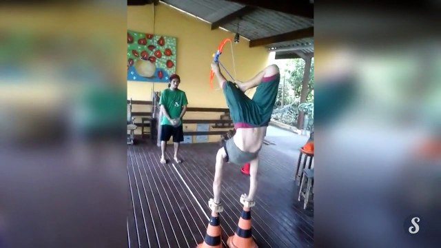 Une femme en équilibre tire à larc avec ses pieds