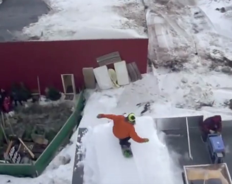 Double crazy jumps from roof to an other on snowboard
