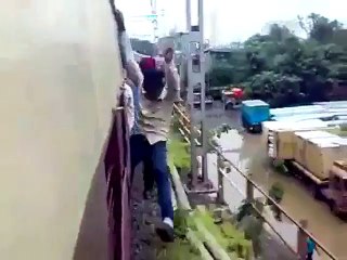 Deux cons font du surf sur le côté du train