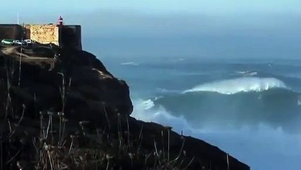 Un fou fais du surf sur une vague géante