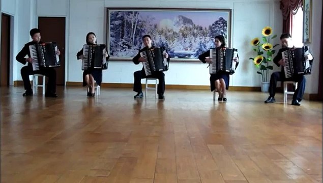 Cinq musiciens font une démonstration d'accordéons