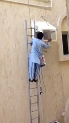 Pakistani Worker Works at 5th Floor on a Hanging Ladder - Postober