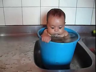 Baby in tub making strange faces