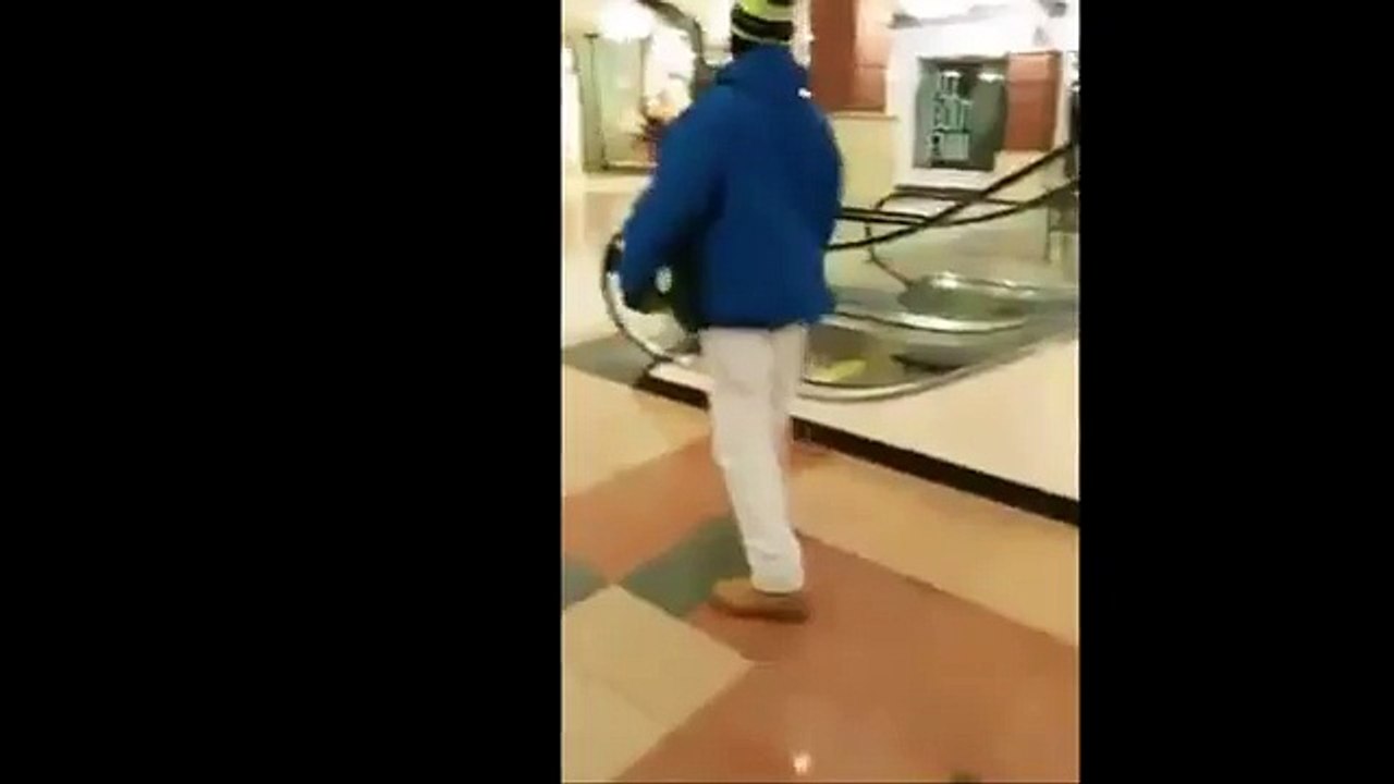 Il essaie de rester suspendu à un escalator