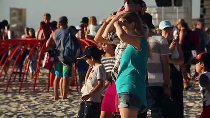 Aboriginal girl stands blindfolded on a beach, asks people to embrace her