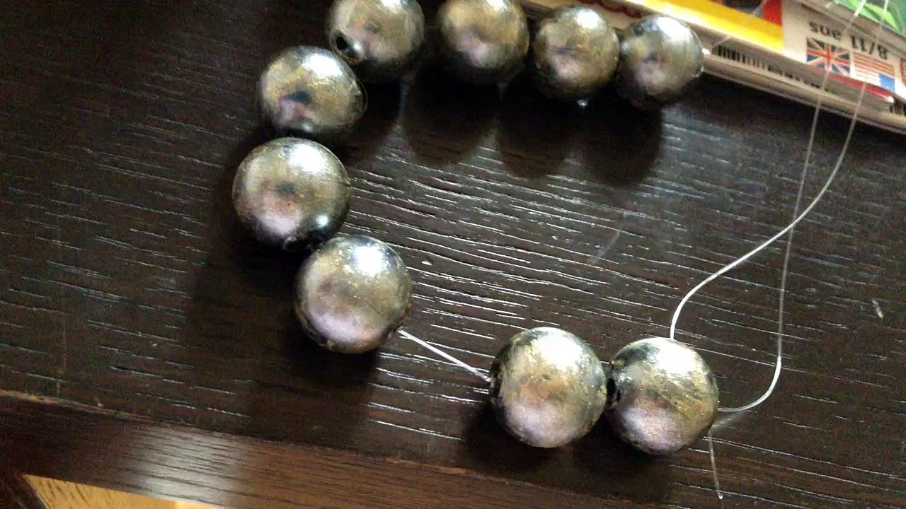 Pour faire briller un collier de perles noirs mettre du verni doré dessus
