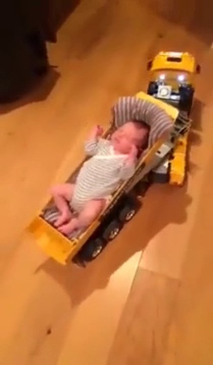 Un bébé endormi dans la remorque d'un camion de chantier