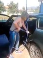 Une femme lave sa voiture au nettoyeur haute pression