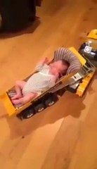 Un bébé s’endort dans un camion téléguidé