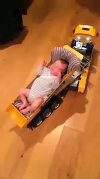 Un bébé endormi dans la remorque d'un camion de chantier