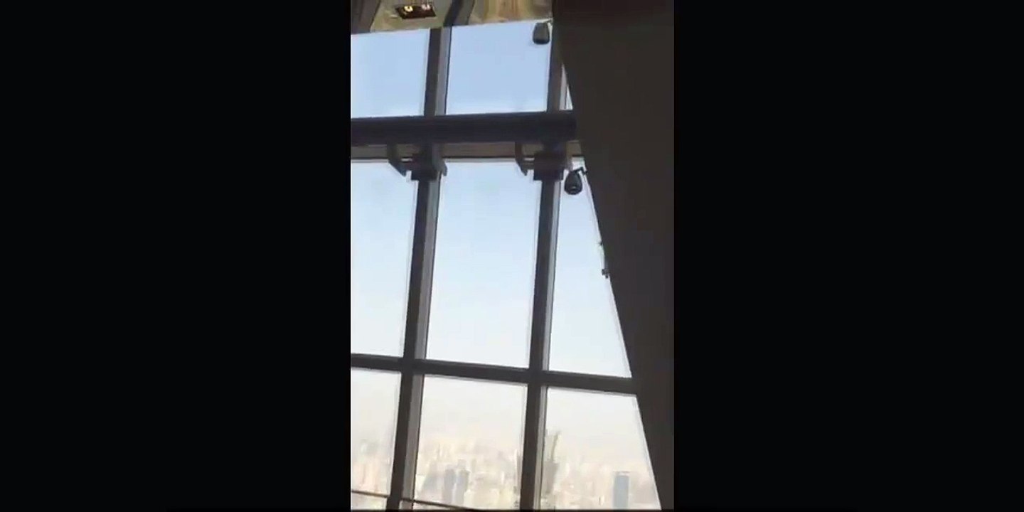 The window washer badly rocked by the wind