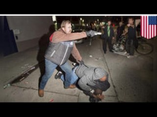 Un policier brandit une arme de point lors d’une manifestation.