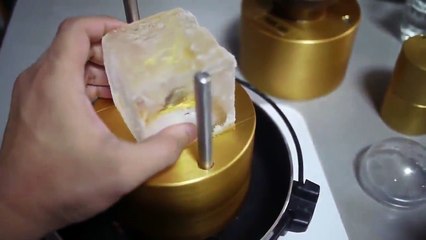 An ice cube turn into an ice sphere using..