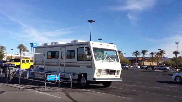 Dog pooping on the dashboard of an old RV in a Walmart parking lot