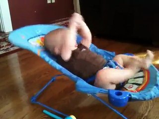 Un bébé fait des abdos sur son lit