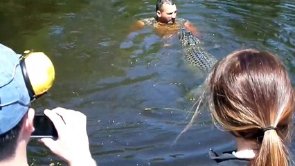 Airboat guide feeding alligator from his mouth