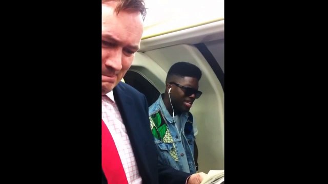Man tries not to laugh while other sings loudly in the subway