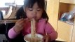 Emilyn eating noodles w/ chopsticks...